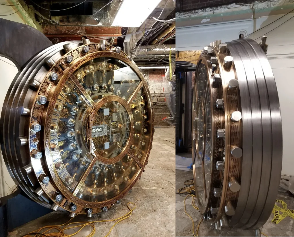 Restored antique bank vault door with intricate metal detailing and polished bronze finish